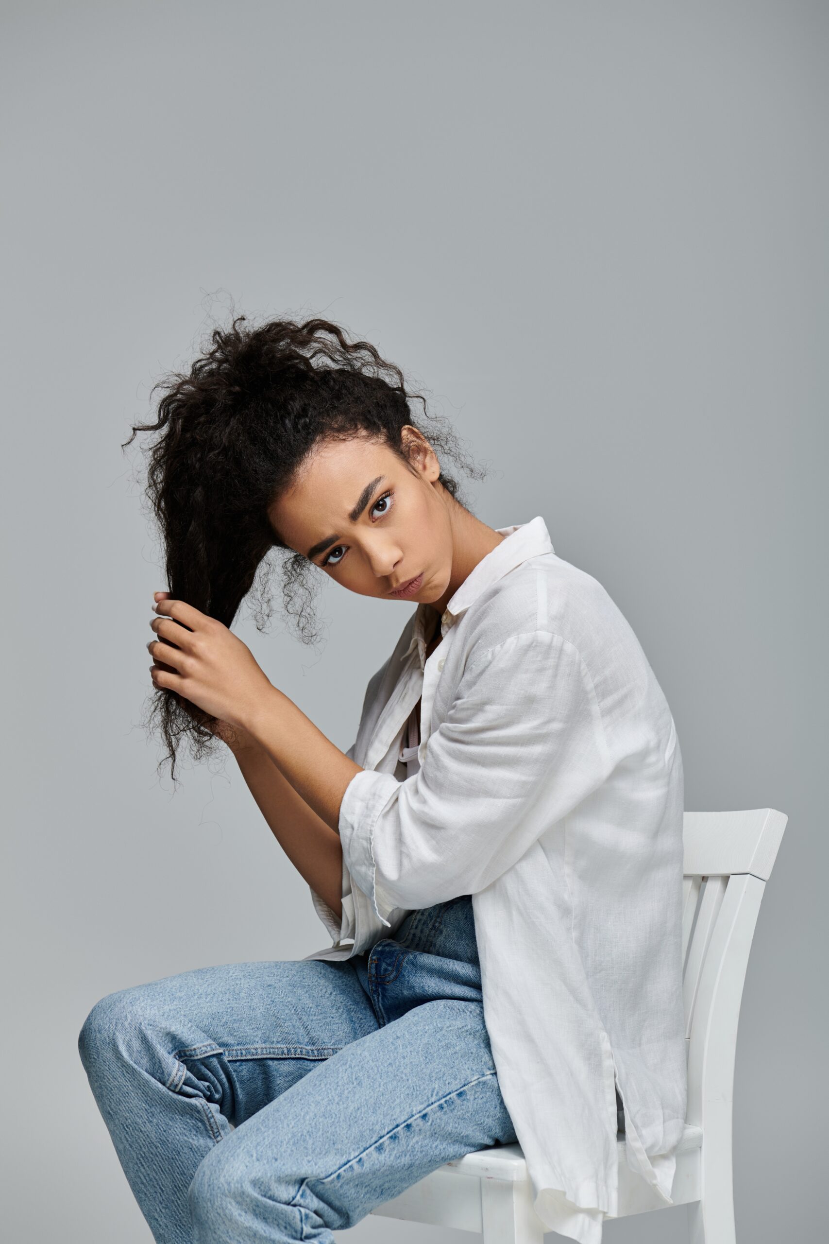 A,Young,Black,Woman,With,Curly,Hair,Sits,On,A